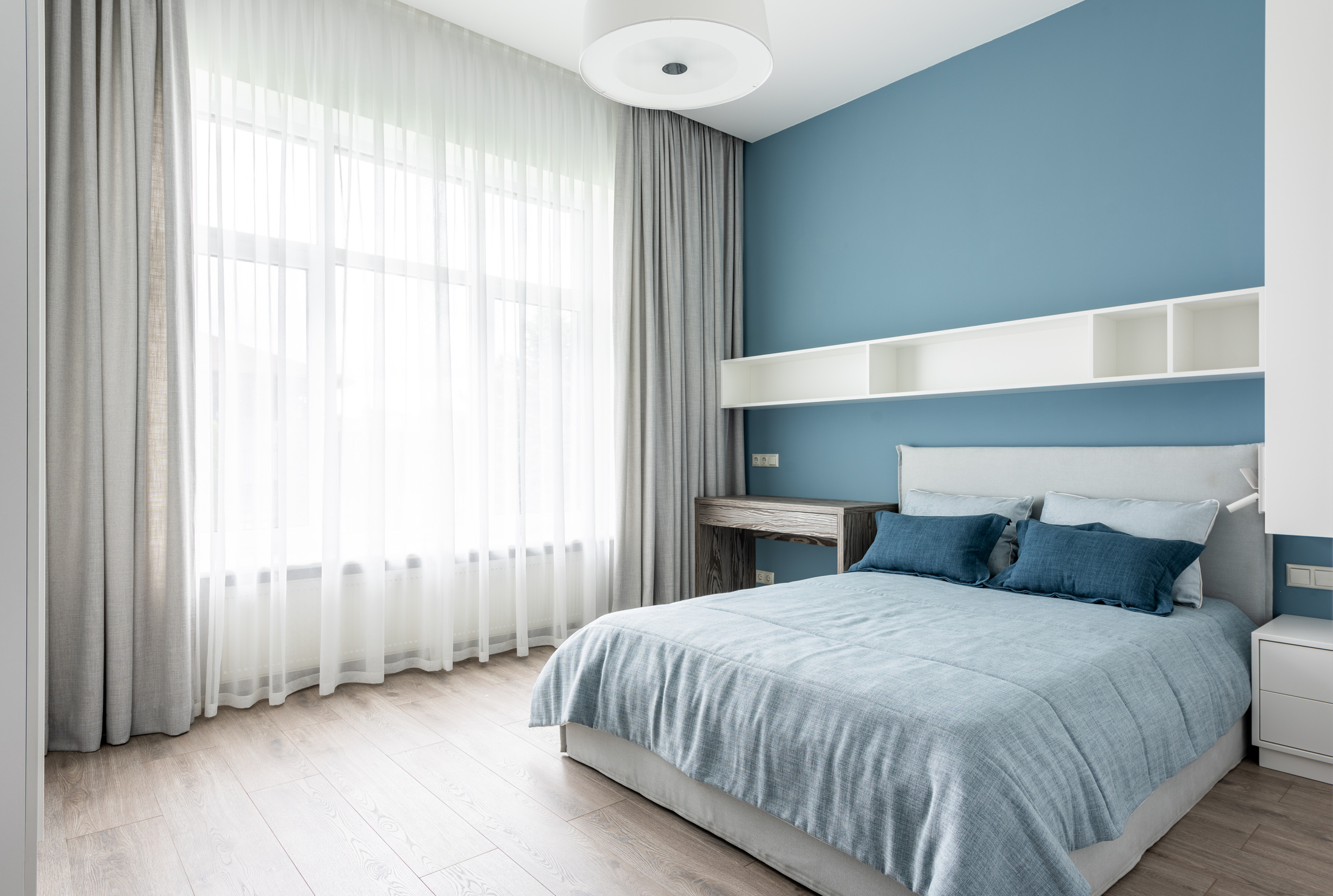 Contemporary bedroom with soft bed and blue pillows